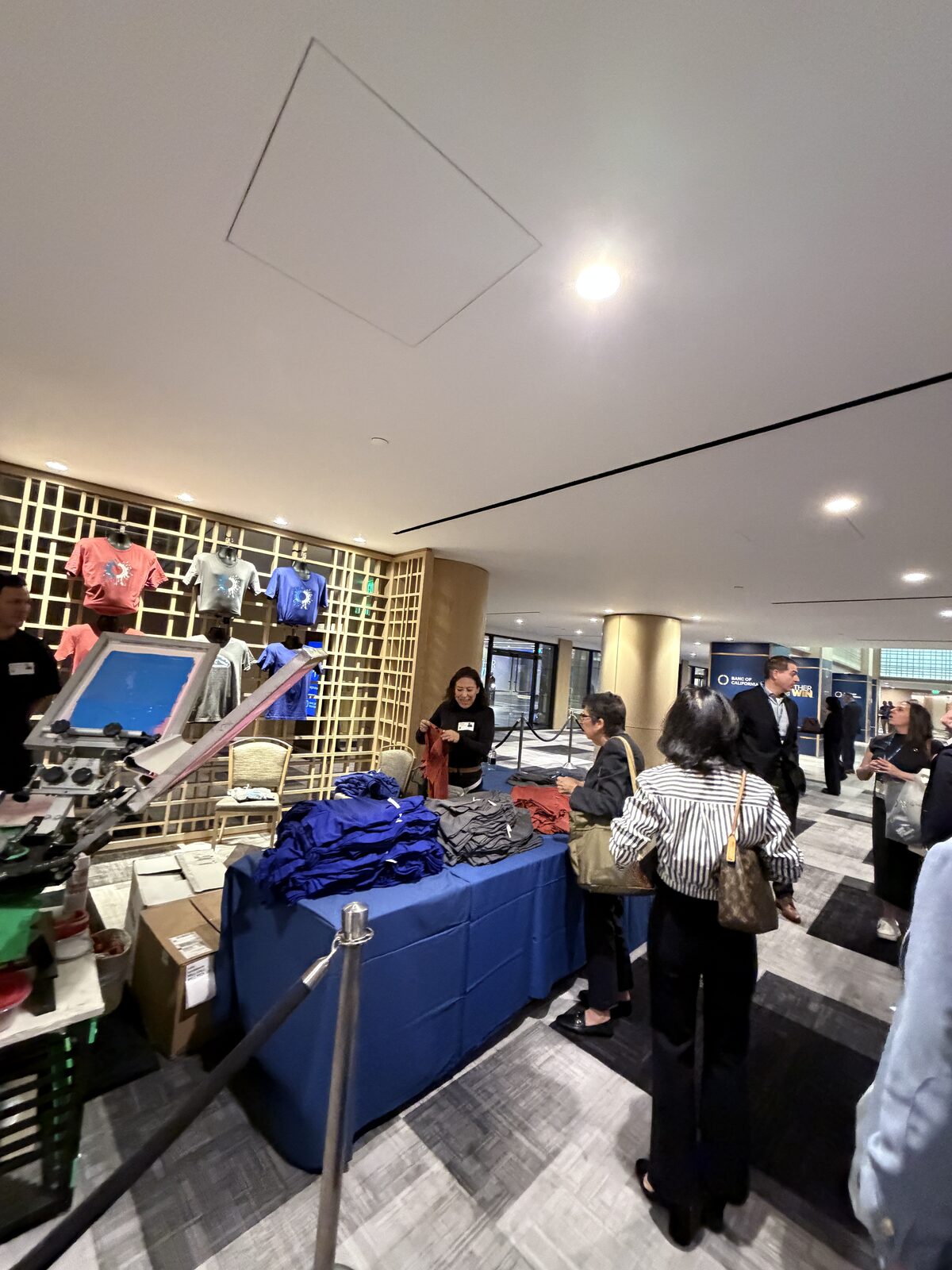 Attendee receiving a freshly printed shirt at a summit booth