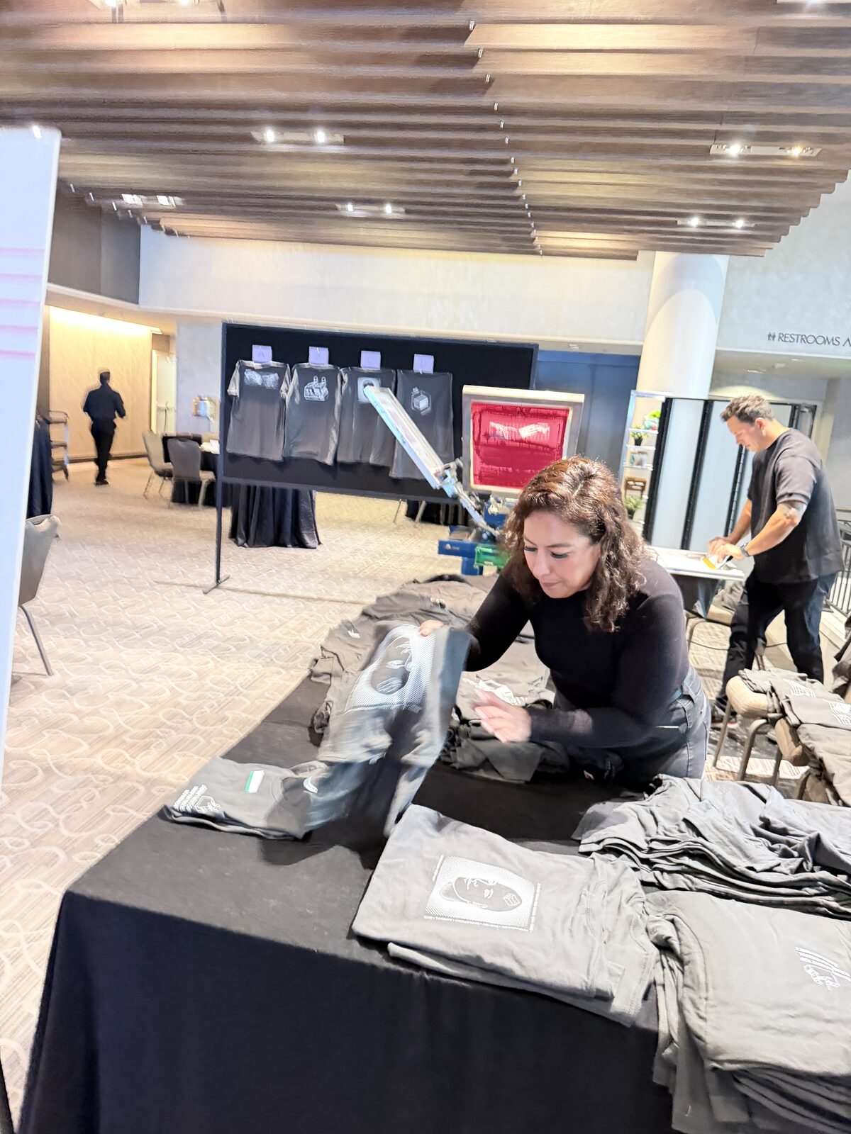 Crew folding freshly printed shirts at a booth